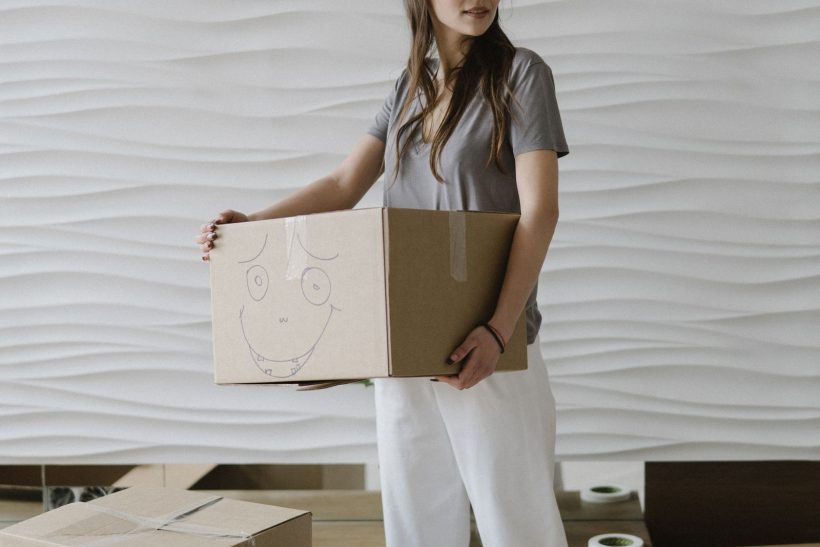 Mover carrying cardboard boxes during a home relocation