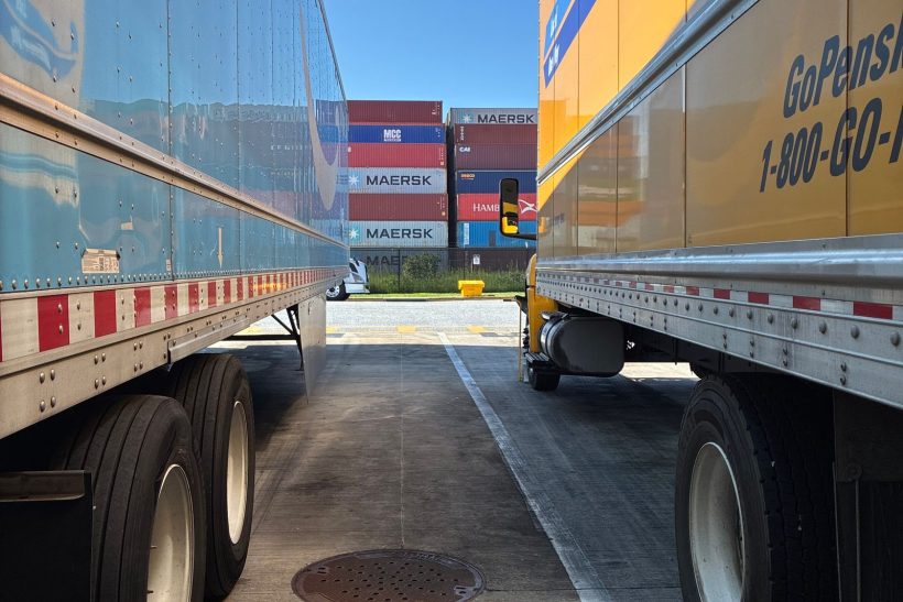 Parked trailers and shipping containers at a logistics yard