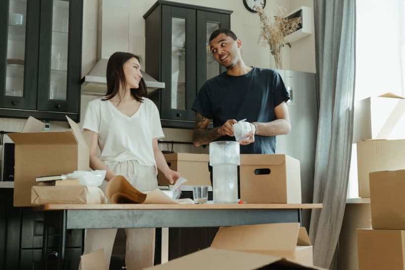 Couple unpacking boxes in the kitchen of their new home